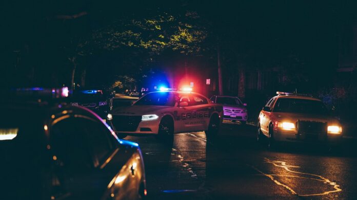 Investigación policial Vehículos policiales con luces de emergencia durante una investigación nocturna