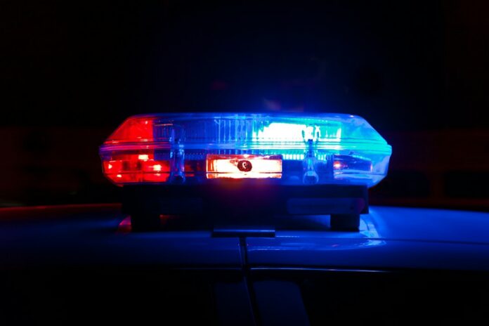 Luces rojas y azules de un vehículo policial durante la noche, imagen de referencia